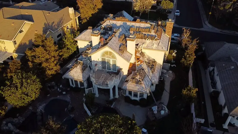 Aerial view of a full roof tear-off at dusk